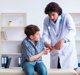 Hand injured boy visiting young male doctor