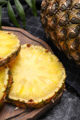 Slices of tasty ripe pineapple on black table, closeup