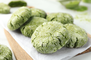 Board with tasty matcha cookies on white table, selective focus