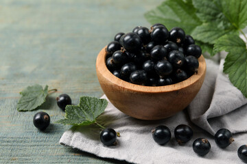 Ripe blackcurrants and leaves on wooden rustic table