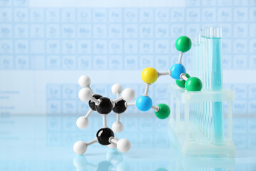 Molecular model and test tubes on light surface