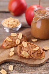 Fototapeta na wymiar Fresh apples with peanut butter on wooden table