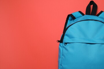 Stylish light blue backpack on red background, top view. Space for text