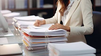 Businesswoman hands working in Stacks of paper files for searching and checking unfinished documents achieves on folders papers at busy work desk office - obrazy, fototapety, plakaty
