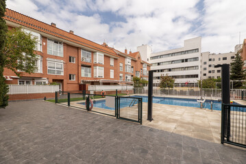 Naklejka premium Community pool in the interior patio of urban residential buildings with slate, white stoneware and green artificial grass floors