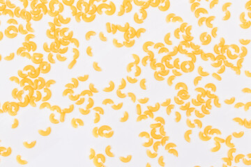 Scattered Uncooked Chifferi Rigati Pasta on White Background. Fat and Unhealthy Food. Classic Dry Macaroni Texture. Italian Culture and Cuisine. Raw Pasta