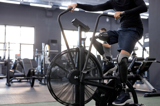 close up cropped shot of male's artificial legs on bike. focus on legs. fitness.