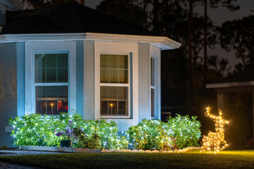 Front yard with brightly illuminated christmas decorations. Outside decor of florida family home for winter holidays