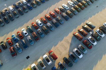 Large parking lot of local dealer with many brand new cars parked for sale. Development of american automotive industry and distribution of manufactured vehicles concept