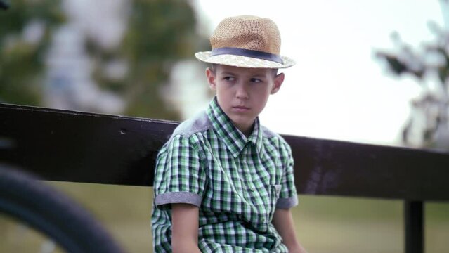 Lonely and Angry: Upset Boy Sitting on a Bench, Gazing Around