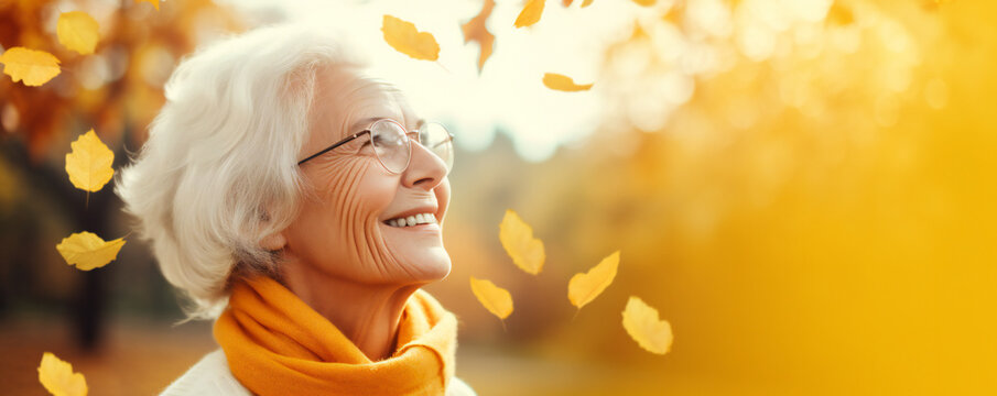 A happy elderly woman laughing in a park in autumn