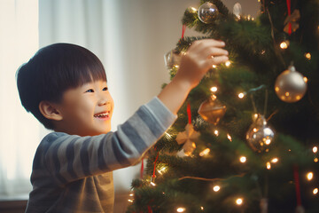 Asian young boy decorating Christmas tree