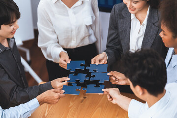 Corporate officer worker collaborate in office, connecting puzzle pieces with report paper on table...