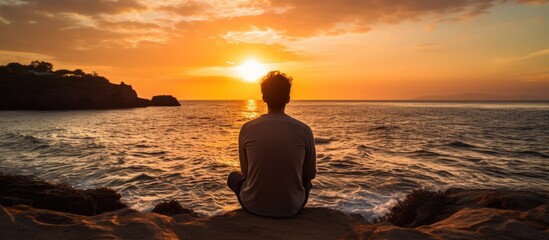Fototapeta premium Man watching sunset over the sea With copyspace for text