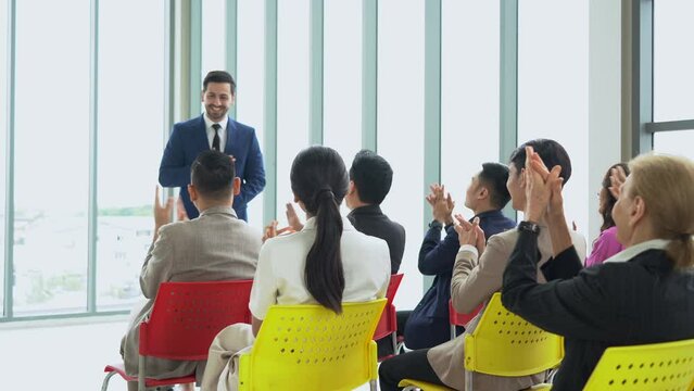 group of diversity business people clapping hands welcome middle eastern business man standing and talking in font of meeting at seminar speaker giving lecture at a business seminar