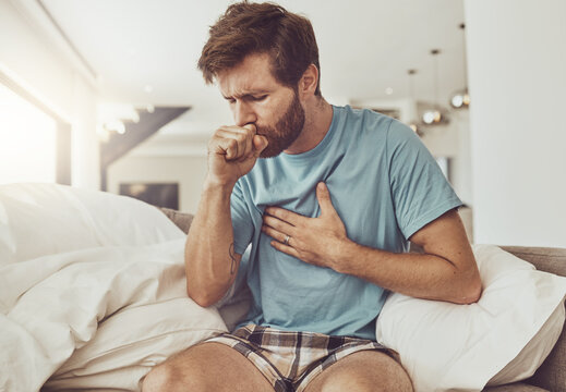 Sick, Coughing And Man On A Sofa With Chest Pain, Tuberculosis Or Influenza At Home. Asthma, Anxiety And Male Person With Breathing Trouble In Living Room With Covid, Pneumonia Or Lung Virus