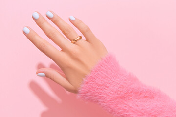 Womans hand with white nail design on pink background. Manicure, pedicure beauty salon concept - obrazy, fototapety, plakaty