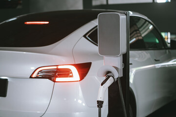 EV electric car recharge at shopping center parking lot charging in downtown city showing urban...