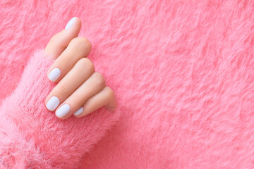 Womans hand with white nail design on pink background. Manicure, pedicure beauty salon concept