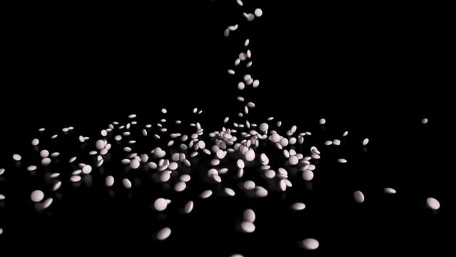 White pills falling on the ground.