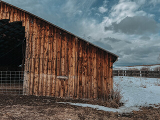 Historic rustic barn set against a snowy Montana landscape