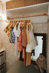 Cute dresses in redecorated closet for baby.