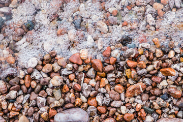 Bubbly water flowing over stones at Lake Superior in Michigan.