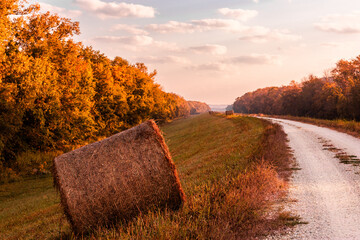 Hay bales on side of country road during autumn morning