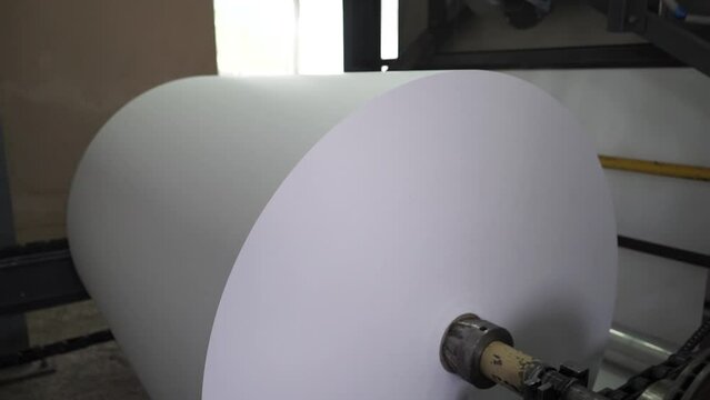 Paper and pulp mill.  Process of various paper products manufacturing indoors. An empty quiet industrial wallpaper and paint factory with giant industrial wall paper rolling machines.
