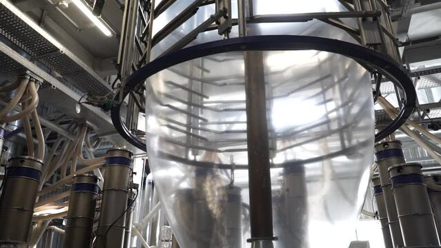 The operation of automatic plastic bag production machine.  Natural color LDPE single layer Shrink film by old technology extrusion blown film plastic bag making machine.
