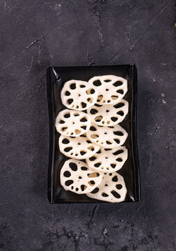 l exotic lotus root on a black plate. Garnish. View from above. Chinese cuisine, hotpot ingredient