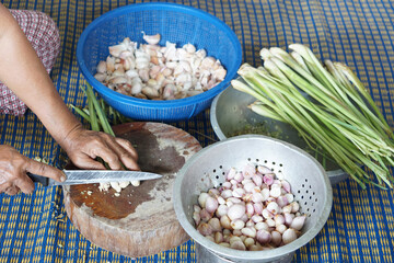 Close up hands use knife to slice lemongrass , shallots and garlic, food ingredients. Concept, traditional cuisine process, Thai local cooking lifestyle. Prepare materials for cooking. 