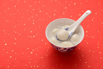 A bowl of rice dumpling is placed on the red festive background of China-Chic Chinese style.