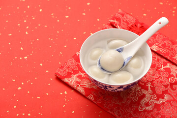 A bowl of rice dumpling is placed on the red festive background of China-Chic Chinese style.