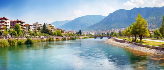 Fototapeta na wymiar Scenic River Embankment and Park Area with Majestic Mountain Backdrop in Alanya, Turkey: Colorful Panoramic Landscape