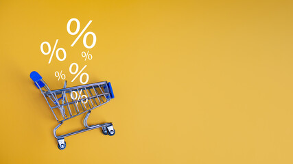 Sale percentage falling in shopping car on yellow background. Shopping online concept, Special...