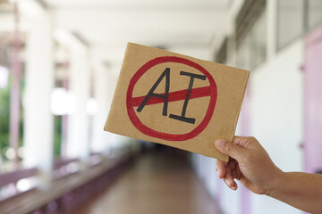 Close up hand holds paper card with No AI,  prohibition sign. Concept, disagree, anti or don't...