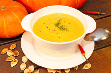 Pumpkin hot puree soup on a wooden table
