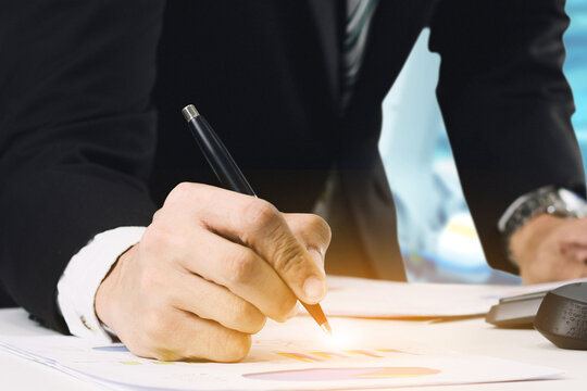 Businessman holding a pen to sign documents