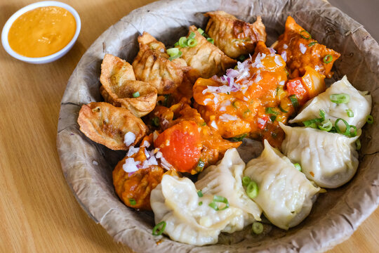 A plate of assorted chicken momos (steamed, fried and chilli sauce dumplings) served on a leaf plate at Tapari Nights, a Nepalese restaurant in Auburn