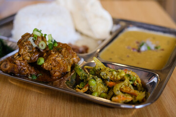 Chicken daal baht power (rice, spinach, lentil, pickle and chicken curry) served on a stainless steel tray at Tapari Nights, a Nepalese restaurant in Sydney, Australia