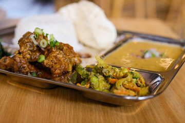 Chicken daal baht power (rice, spinach, lentil, pickle and chicken curry) served on a stainless steel tray at Tapari Nights, a Nepalese restaurant in Sydney, Australia