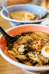 Two bowls of tonkotsu ramen (shoyu base and black garlic oil) with soft-boiled eggs, bamboo shoot and warabi (bracken fern fronds) at Mikazuki Japanese restaurant in Sydney