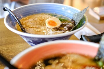 Two bowls of tonkotsu ramen (shoyu base and black garlic oil) with soft-boiled eggs, bamboo shoot and warabi (bracken fern fronds) at Mikazuki, a Japanese restaurant in Sydney