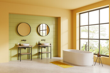 Yellow and green bathroom with double sink and tub