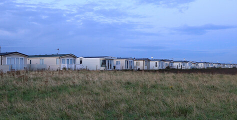 Fototapeta na wymiar View of a self catering static caravan holiday park in the light of dawn. This is a very popular and economical way to stay