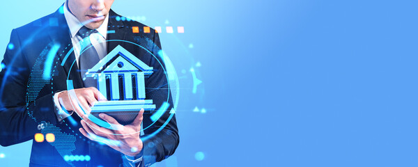 Businessman using tablet, digital bank hologram and empty blue background