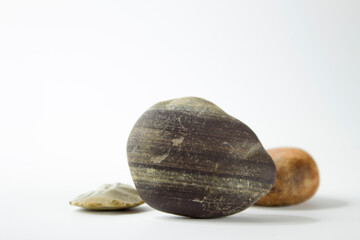 Three pebble stones on a white background with space for text