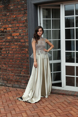 Fototapeta premium Perfect young woman in silver evening gown standing on the terrace