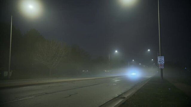 Cars drive on road of smoke and fog at night time. Wide shot fotage